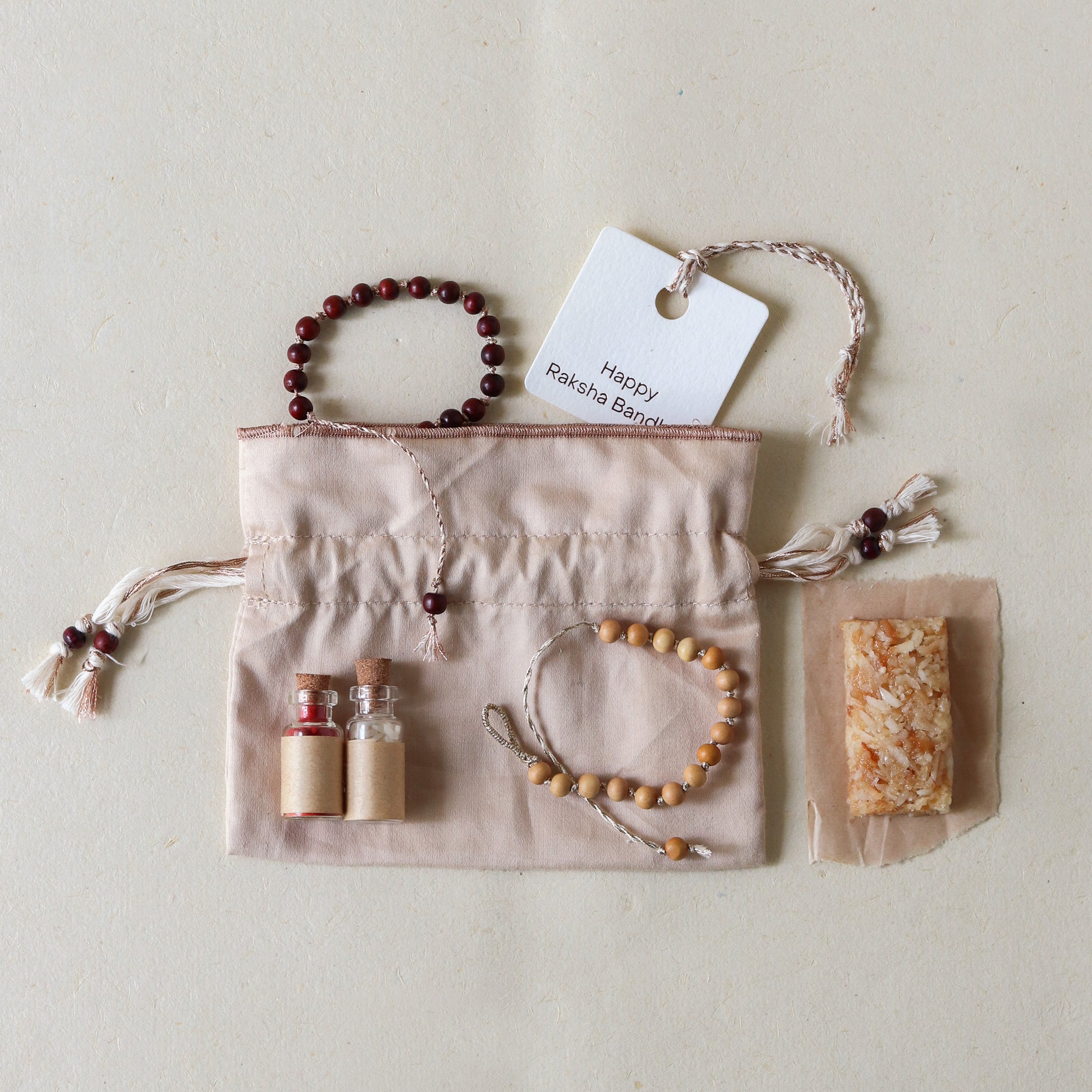 Sacred Sandalwood: Rakhi Set ( 2 Rakhis - 1 Sweet )