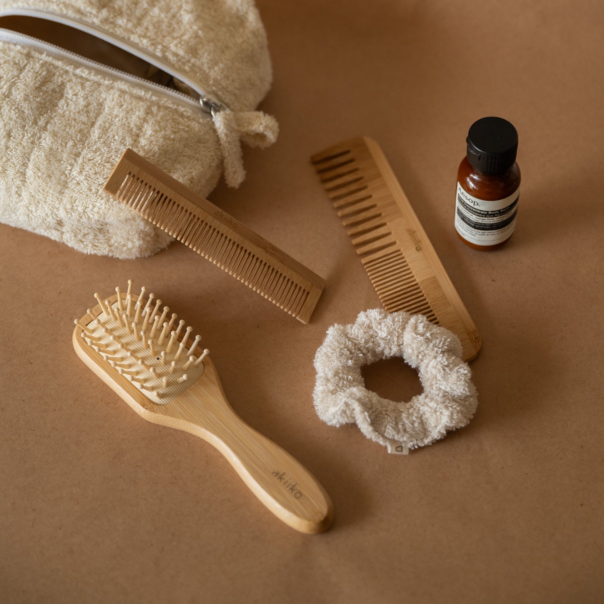 Bamboo Hair Set featuring a bamboo hair brush, pocket comb, regular comb, soft terry scrunchie, all stored in a terry pouch.