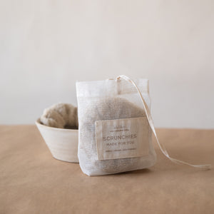 Set of three fluffy terry cotton cloud scrunchies in neutral tones, soft and lightweight, with pouch.