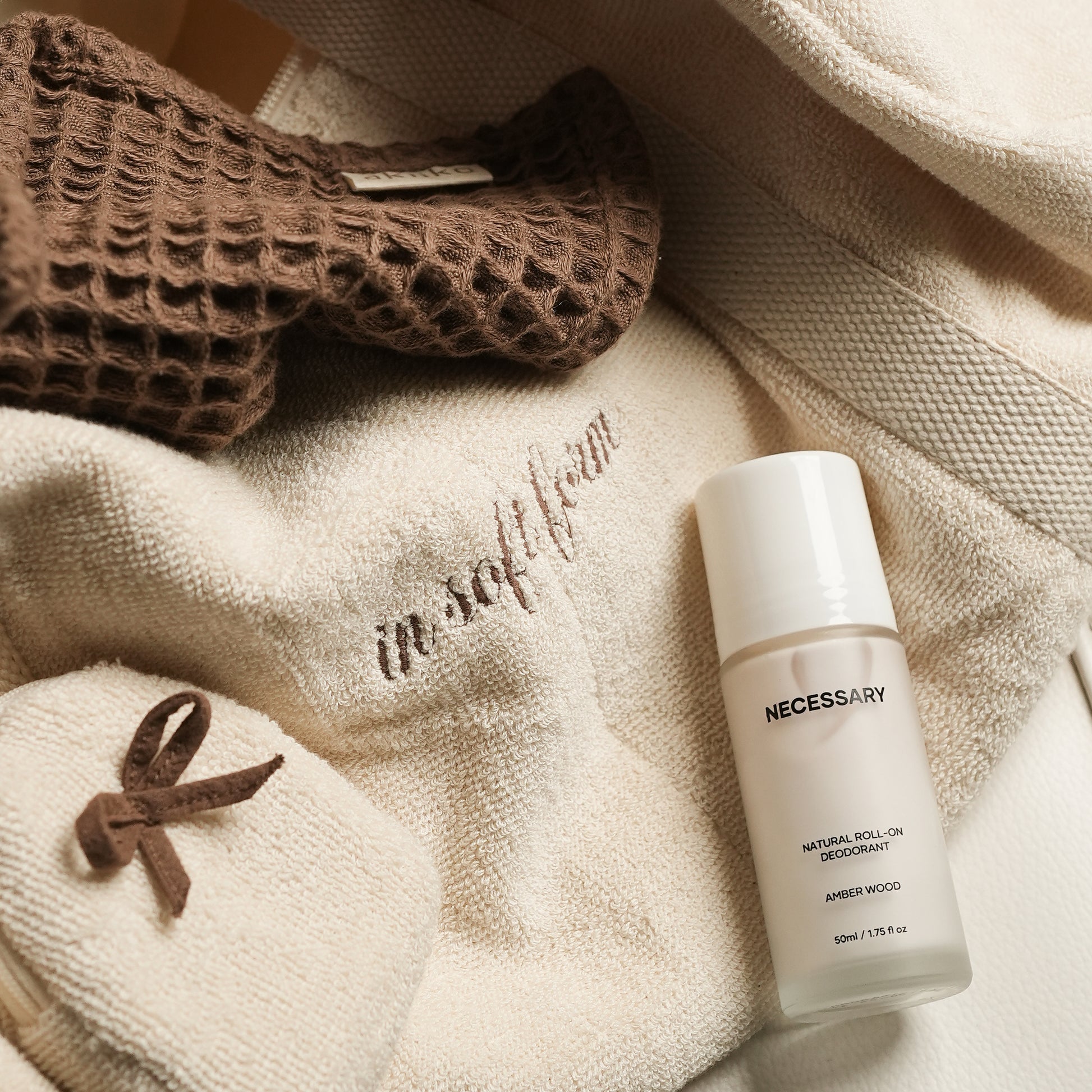Fresh Companion Set featuring a soft terry cotton duffle with espresso embroidery and charm, matching espresso waffle face towel, and Necessary Amber Wood aluminum-free deodorant.