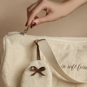 Fresh Companion Set featuring a soft terry cotton duffle with espresso embroidery and charm, matching espresso waffle face towel, and Necessary Amber Wood aluminum-free deodorant.