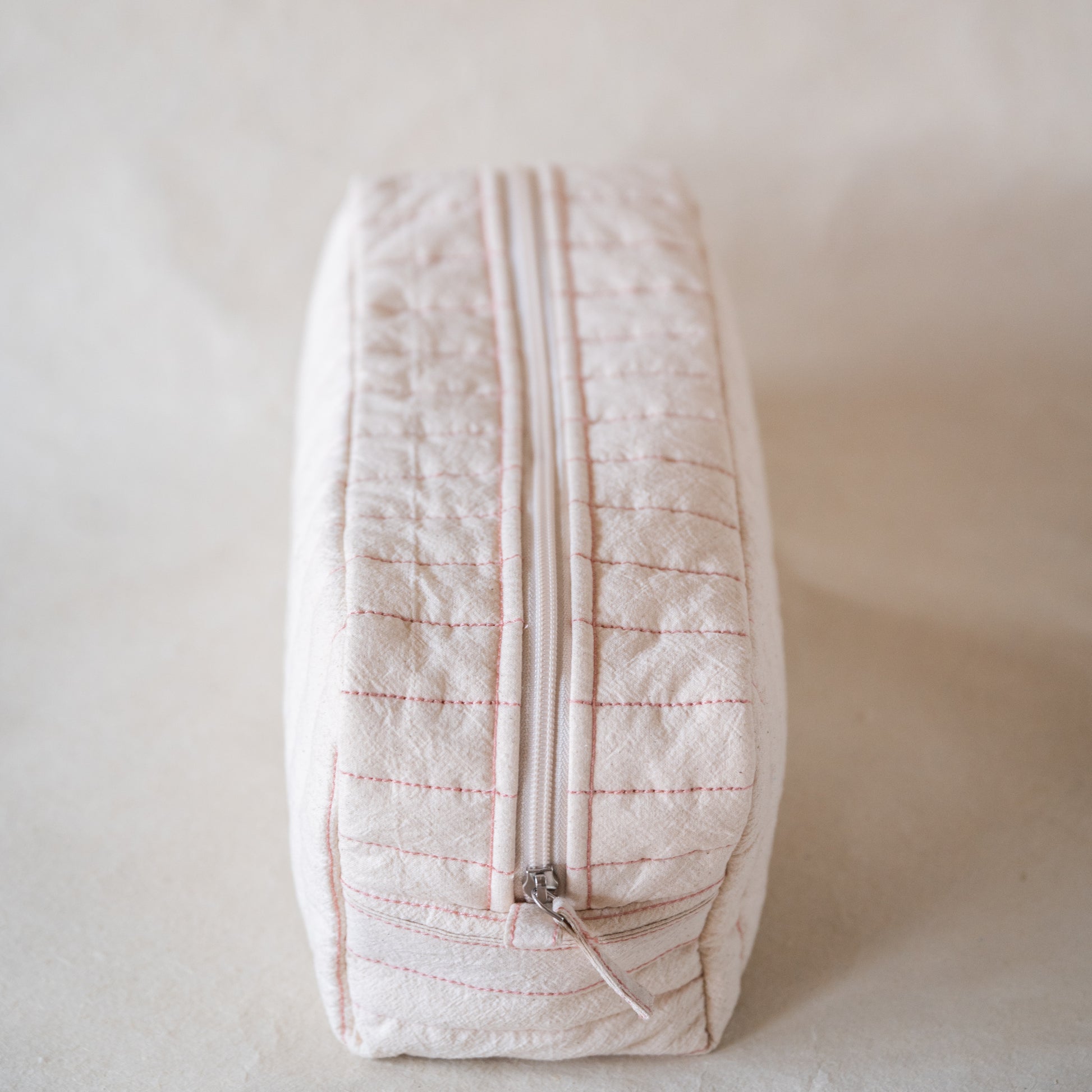 Long curved crinkle-cotton pouch with “look good” pink embroidery, up view
