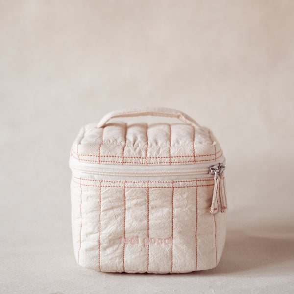 Pink-striped square vanity pouch with “feel good” embroidery, front view