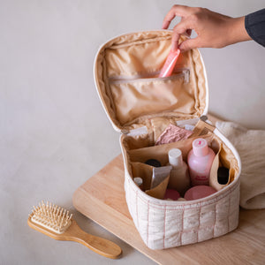 Pink-striped square vanity pouch with “feel good” embroidery, front view