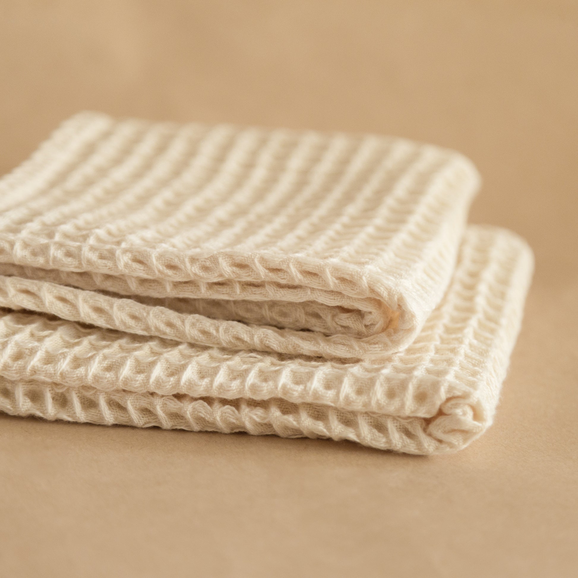Set of four pique waffle cotton face towels, 30x30 cm, soft, plush, and absorbent with textured weave.