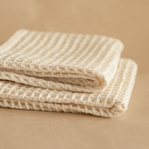 Set of four pique waffle cotton face towels, 30x30 cm, soft, plush, and absorbent with textured weave.