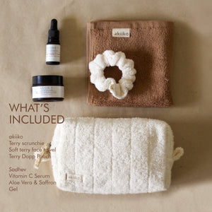 Rise Softly AM Skincare Routine set featuring vitamin C serum, aloe vera gel, ivory terry pouch and scrunchie, and a pecan soft terry face towel.