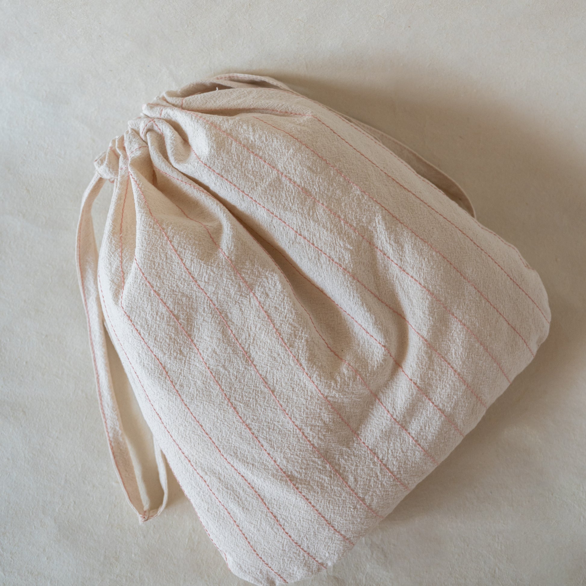 Rosette Soft Towel Gift Set featuring one plush soft terry bath towel, two matching hand towels, and a crinkled cotton drawstring bag with pink thread details.