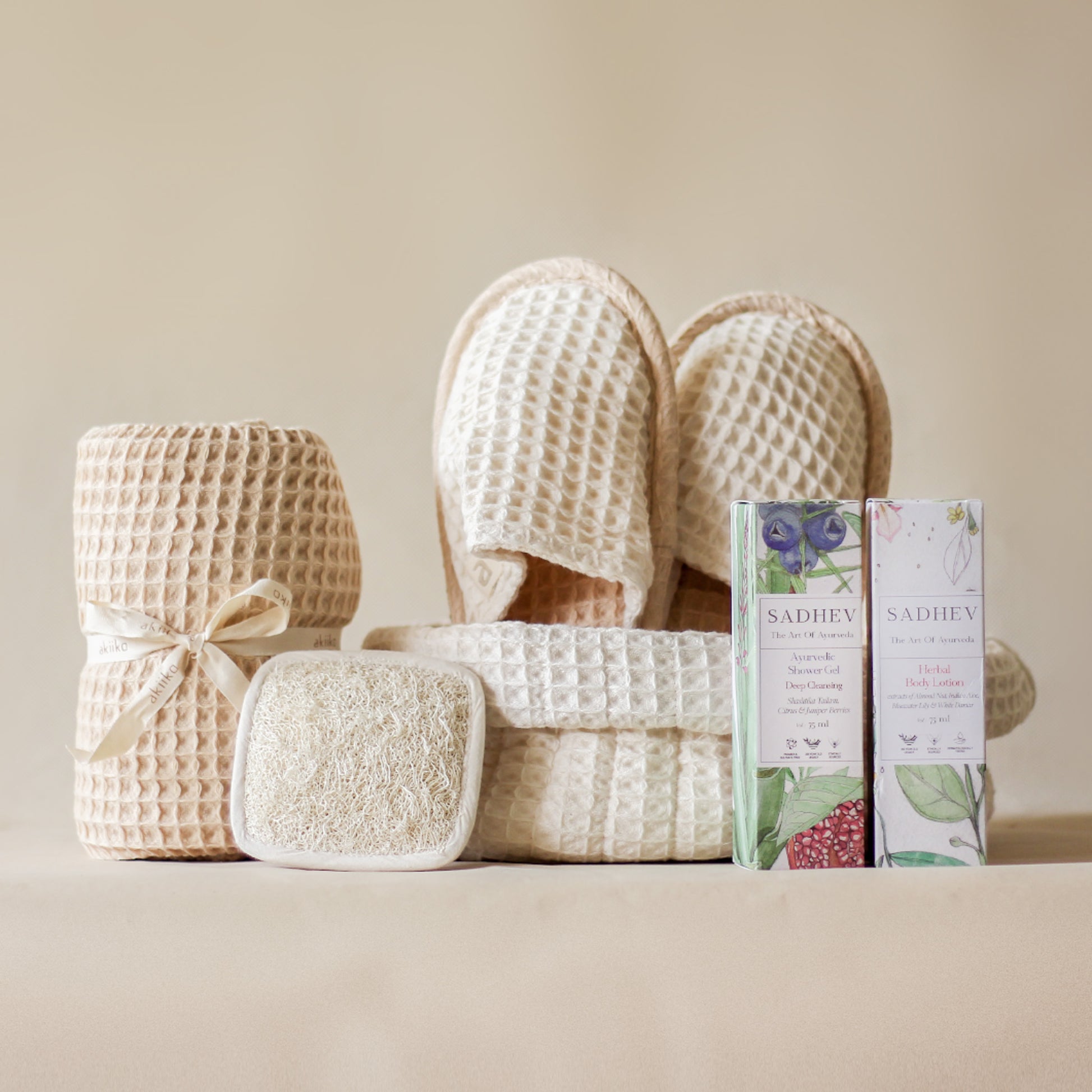 Soak & Soothe Bath Kit featuring Ayurvedic shower gel, body lotion, waffle luffa scrubber, latte waffle bath towel, cozy bath slippers, and a waffle storage basket.