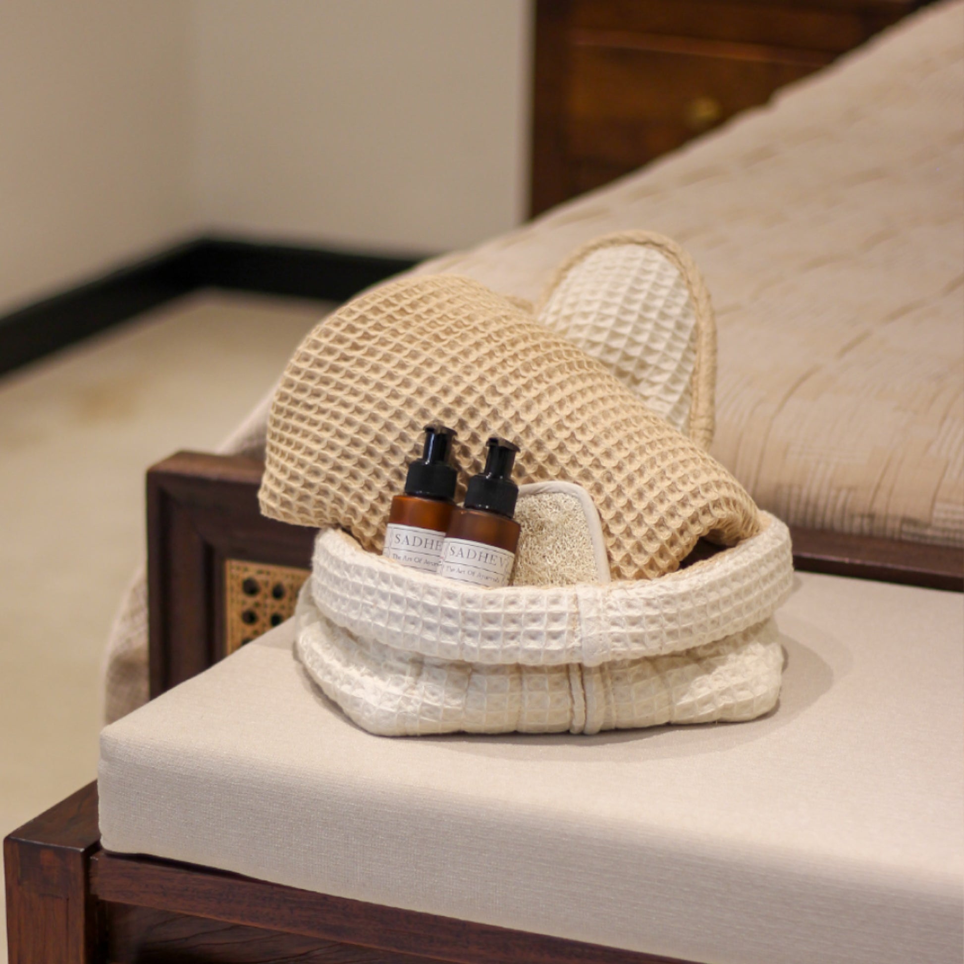 Soak & Soothe Bath Kit featuring Ayurvedic shower gel, body lotion, waffle luffa scrubber, latte waffle bath towel, cozy bath slippers, and a waffle storage basket.