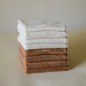 Pack of four soft terry cotton face towels with zero-twist texture, plush and highly absorbent.