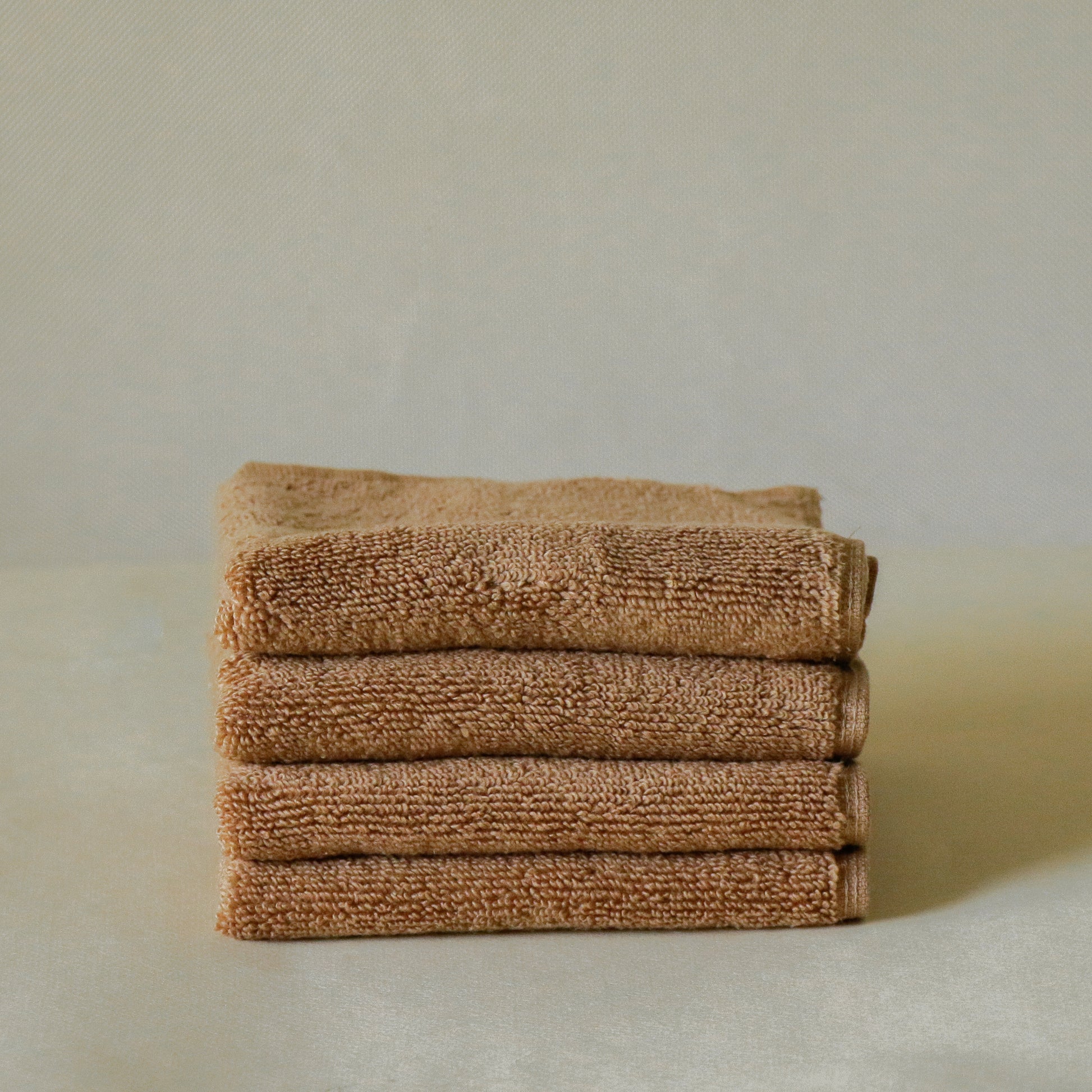 Pack of four soft terry cotton face towels with zero-twist texture, plush and highly absorbent.