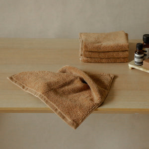 Pack of four soft terry cotton face towels with zero-twist texture, plush and highly absorbent.