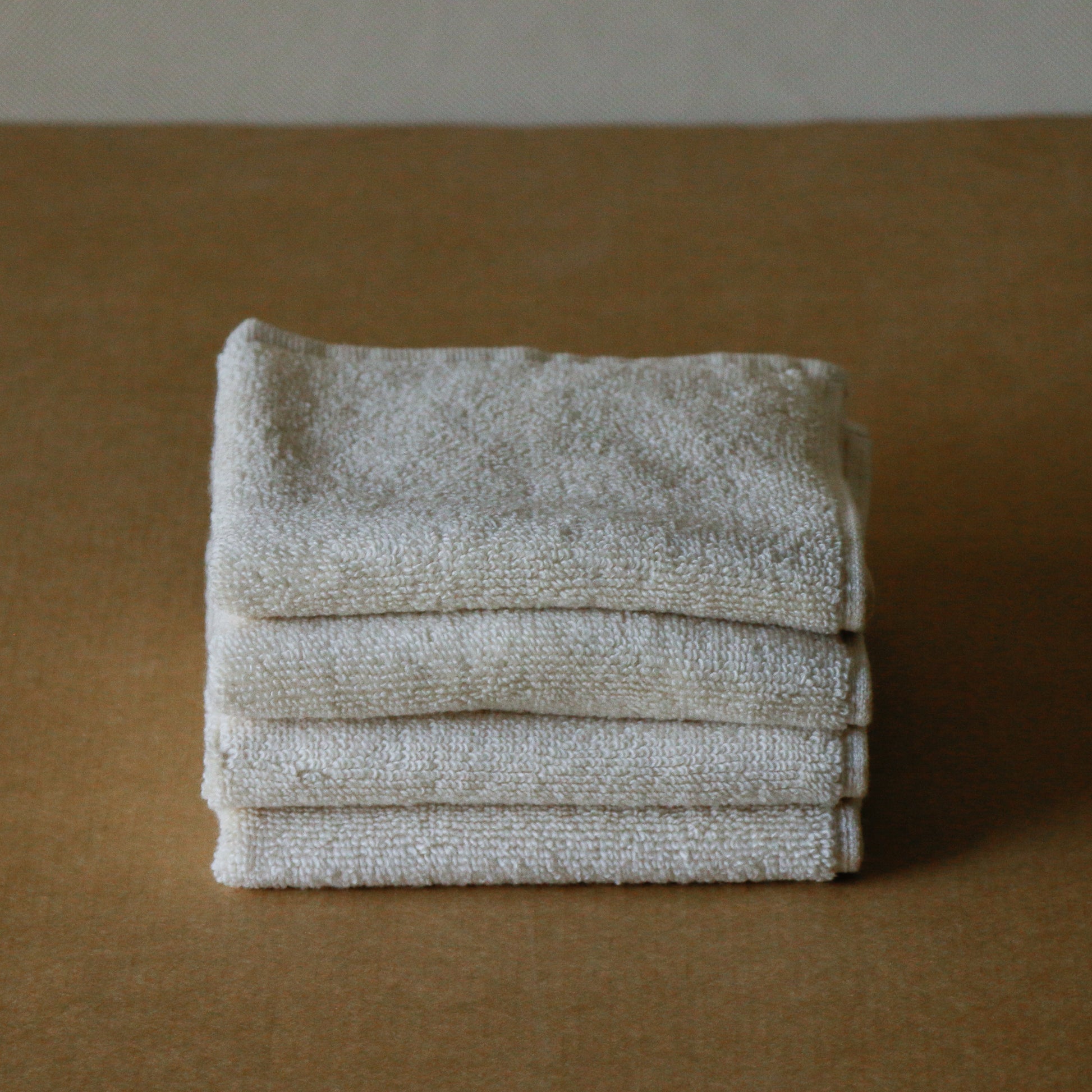 Pack of four soft terry cotton face towels with zero-twist texture, plush and highly absorbent.