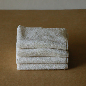 Pack of four soft terry cotton face towels with zero-twist texture, plush and highly absorbent.
