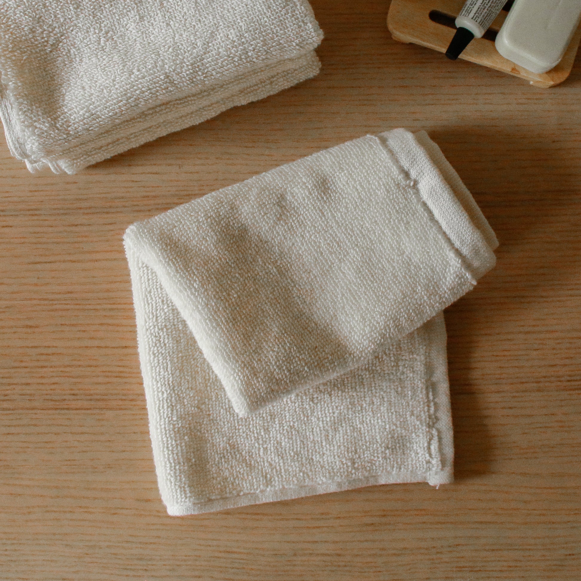 Pack of four soft terry cotton face towels with zero-twist texture, plush and highly absorbent.