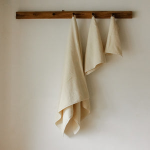 Light-colored soft terry cotton towel set with bath, hand, and face towels, plush and highly absorbent.