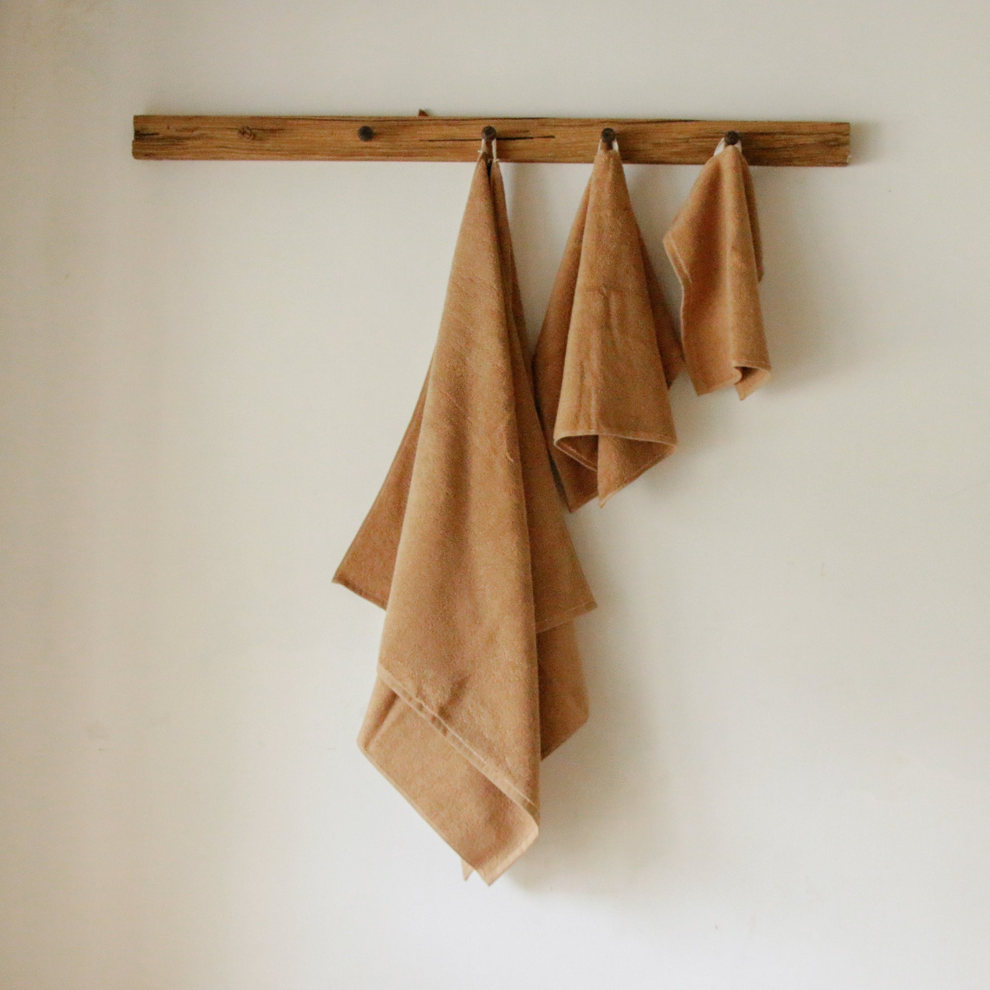 Light-colored soft terry cotton towel set with bath, hand, and face towels, plush and highly absorbent.