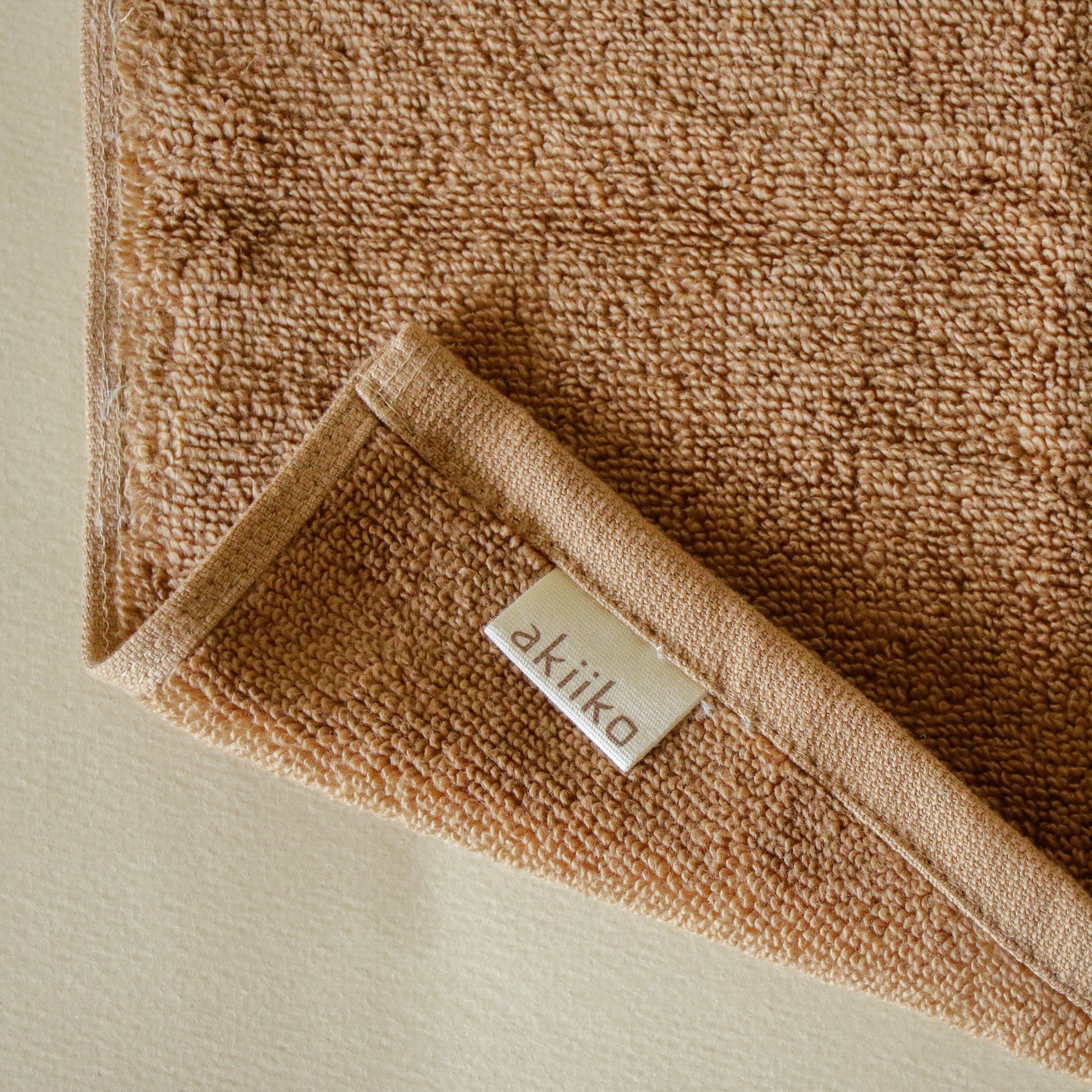 Light-colored soft terry cotton towel set with bath, hand, and face towels, plush and highly absorbent.