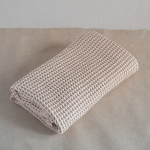 Latte-colored waffle bath towel, 135x75 cm, soft, lightweight, and absorbent, made from cotton and luffa blend.