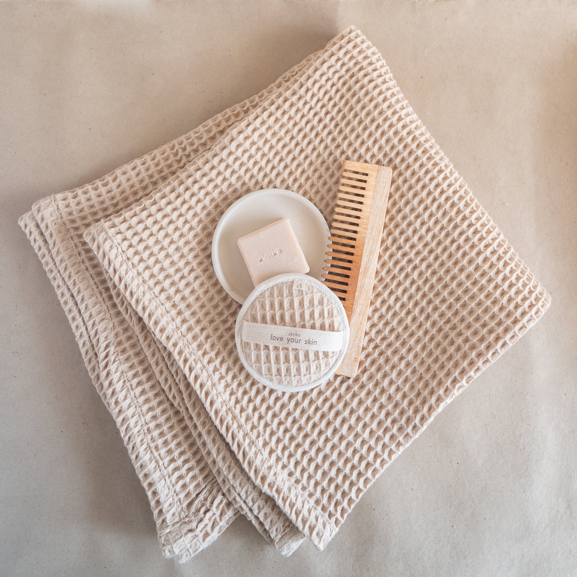 Latte-colored waffle bath towel, 135x75 cm, soft, lightweight, and absorbent, made from cotton and luffa blend.