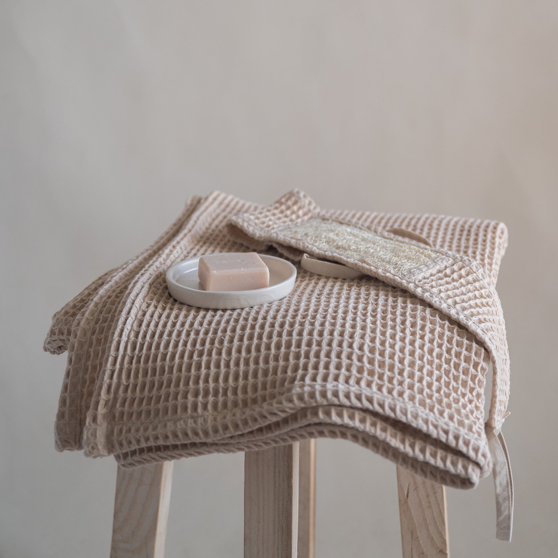 Latte-colored waffle bath towel, 135x75 cm, soft, lightweight, and absorbent, made from cotton and luffa blend.
