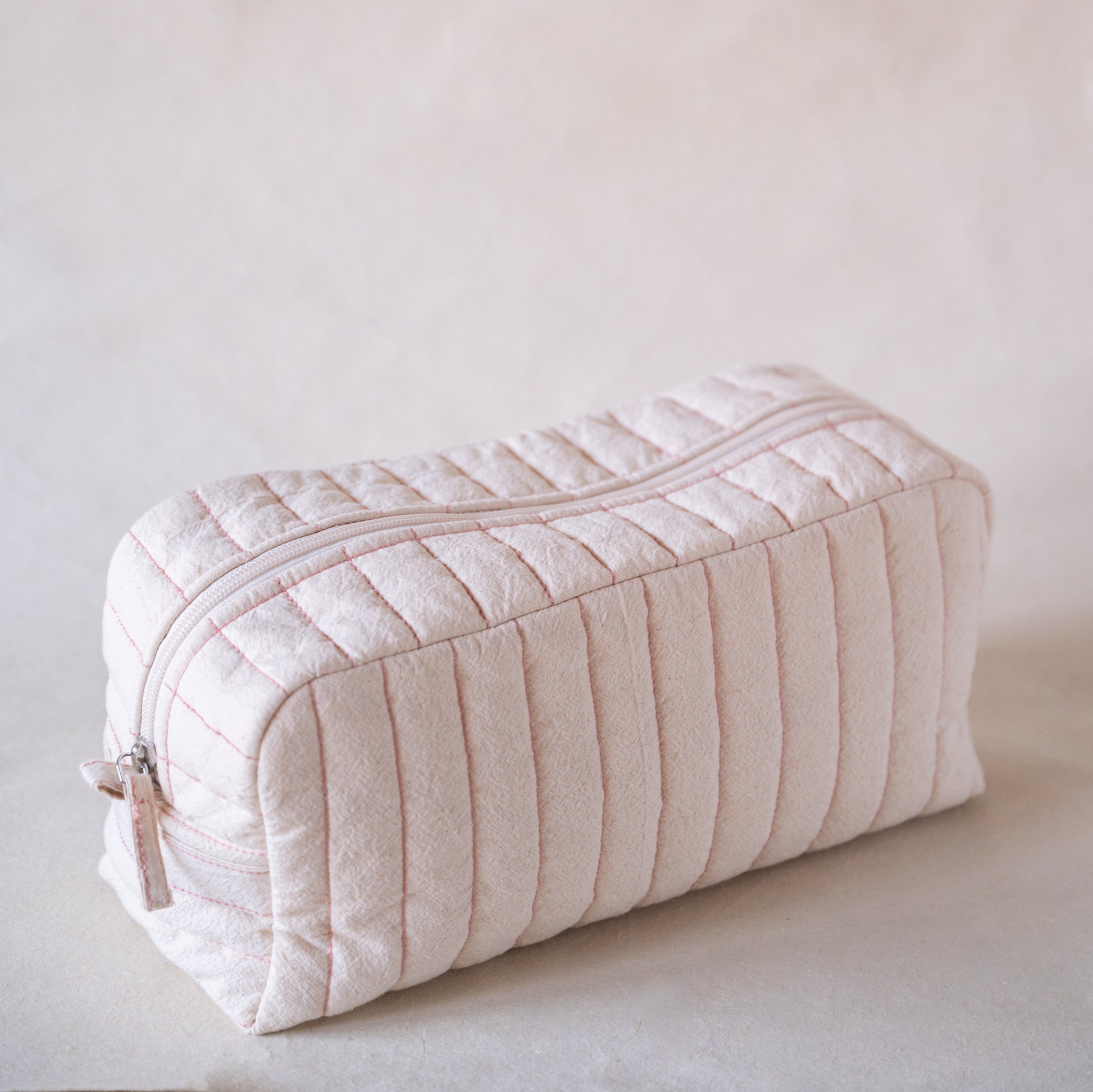 Long curved crinkle-cotton pouch with “look good” pink embroidery, side view