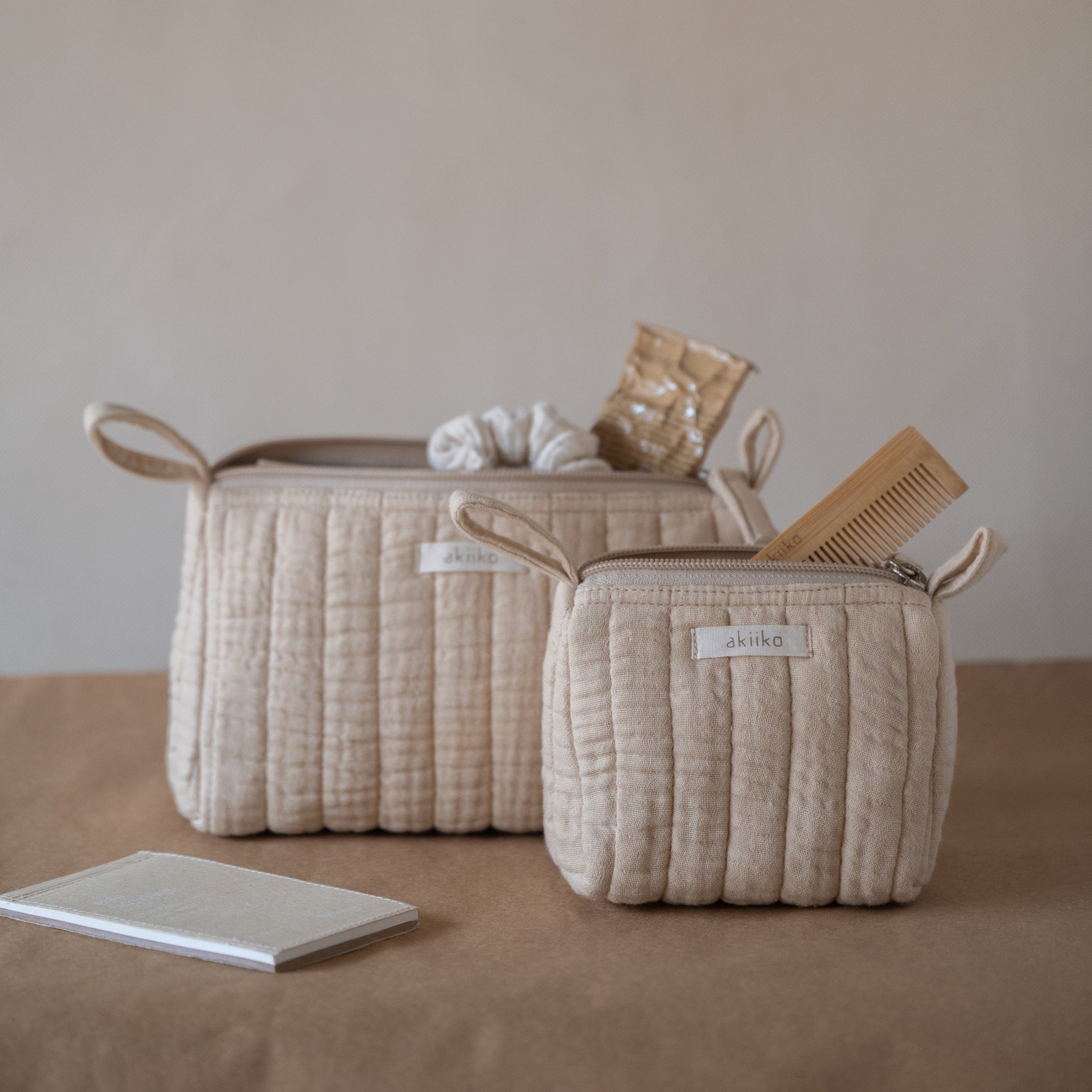 Set of three quilted muslin triangle pouches with zip closures, front view