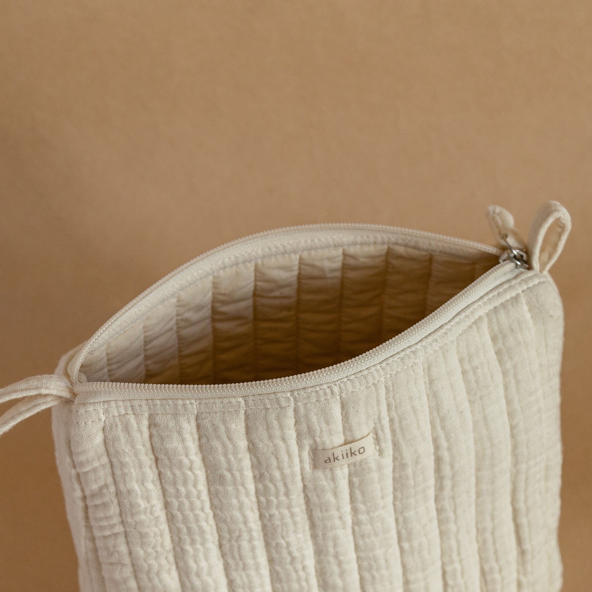 Set of three quilted muslin triangle pouches with zip closures, side view