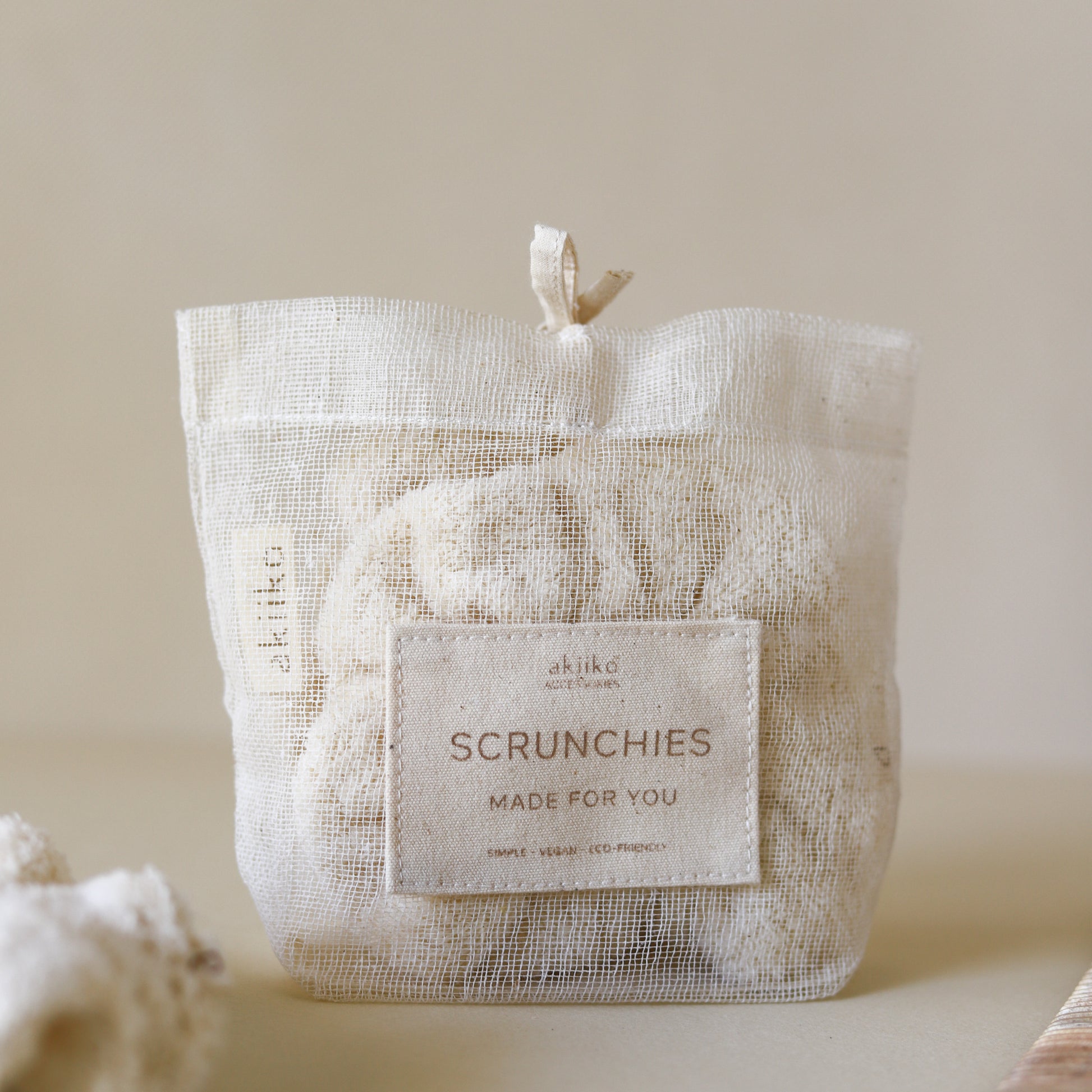 Set of three fluffy terry cotton cloud scrunchies in neutral tones, soft and lightweight, with storage bag.