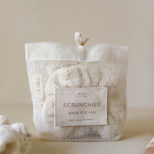 Set of three fluffy terry cotton cloud scrunchies in neutral tones, soft and lightweight, with storage bag.